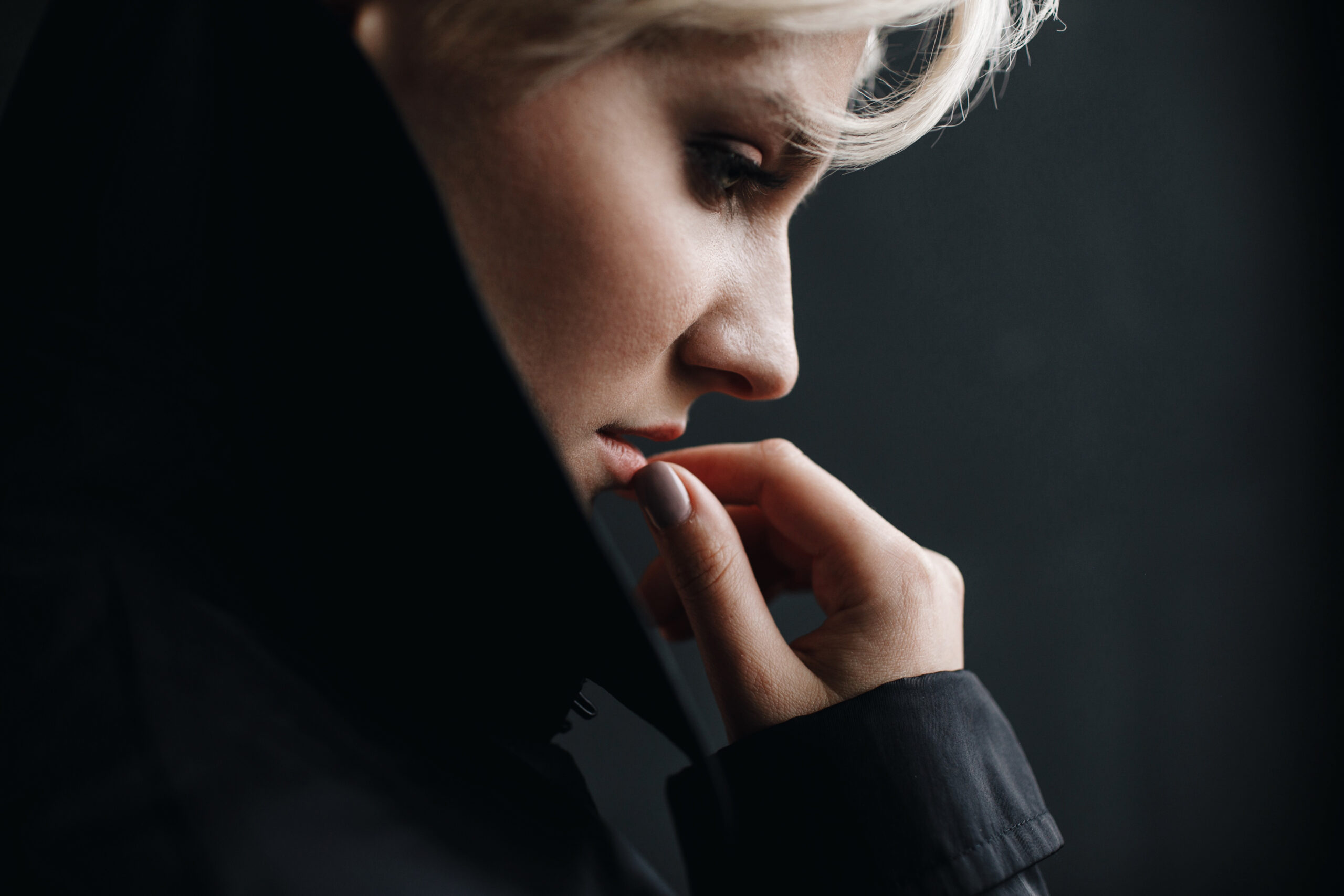 Profile of a beautiful thoughtful woman touching her lips tender